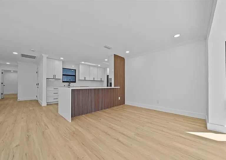 Style SPC Lite 5.5mm light oak luxury vinyl plank running through an open-plan kitchen and living room