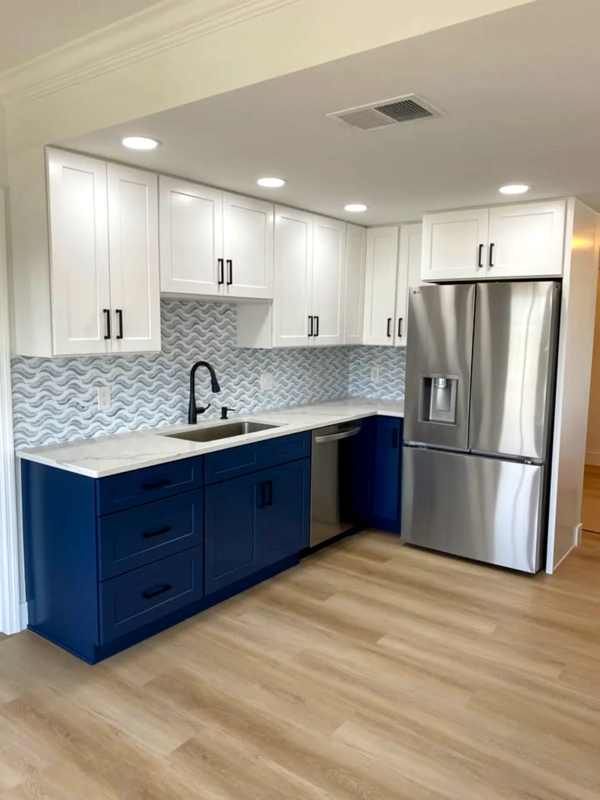 Navy and white kitchen with wave mosaic backsplash
